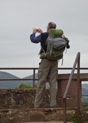 A pilgrim preparing to start the El Camino takes a photograph from the Citadel overlooking Saint Jean Pied de Port. The scallop shell on his pack is the traditional sign of a pilgrim.
